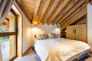 a bedroom with a bed and a large window at Chalets Killington #4 - 4 guests in Les Allues