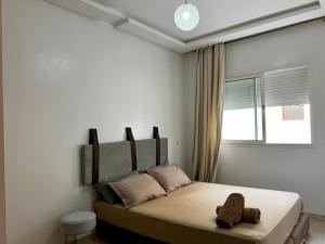 a bedroom with a bed with a teddy bear on it at Apartment Casa Marina - Borgone, Ocean & Hassan II Views in Casablanca