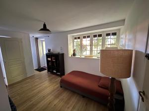 a living room with a bed and a window at La Haute Trémière in Charenton sur Cher