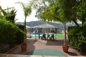 a patio with a table and a pool with trees at Hotel Miravalle in Misilmeri