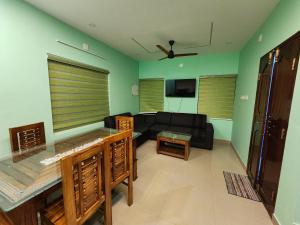 a living room with a black couch and a tv at ILANJI TREE Inn in Cochin