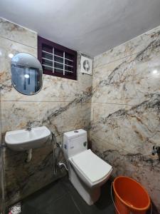 a bathroom with a white toilet and a sink at ILANJI TREE Inn in Cochin