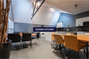 a room with tables and chairs and a kitchen at Fresh Modern Suite, Close To City Hotspots in Oss
