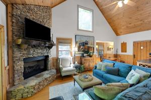 a living room with a blue couch and a stone fireplace at 5br Waterfront Creek Home Hot Tub & Views in McCaysville