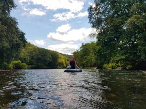a man is sitting on a raft on a river at 5br Waterfront Creek Home Hot Tub & Views in McCaysville +37 photos