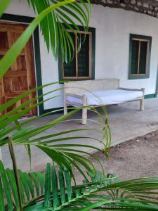 een bankje op de veranda van een huis bij Gede Guest Homes in Watamu