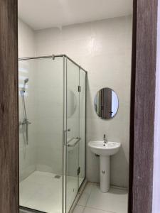 a bathroom with a glass shower and a sink at Crystal's apartment in a secure estate with pool in Ibeju