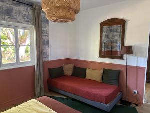 a couch sitting in a corner of a room at La Haute Trémière in Charenton sur Cher