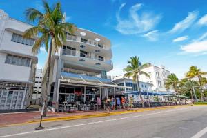 Un edificio con palmeras frente a una calle. en Cozy Studio Ocean Drive - Roof Top Pool with Bar, en Miami Beach