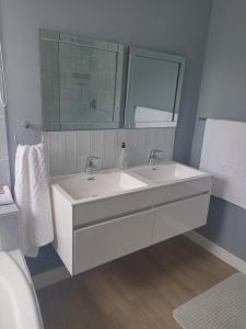 Un baño con un lavabo blanco y un espejo. en Mountain View, en Hermanus