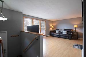 a living room with a black leather couch and a window at Northside Abode Close to Downtown in Missoula