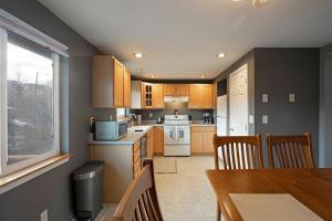 a kitchen with wooden cabinets and a table and chairs at Northside Abode Close to Downtown in Missoula
