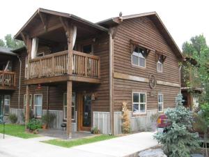 a log cabin with a deck and a porch at Trail Street Condo Downstairs in Missoula