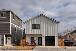a white building with a garage next to a house at Modern abode in Central Missoula! in Missoula