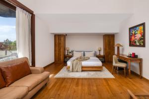 a bedroom with a bed and a couch and a desk at La Muraille, Galle Fort in Galle