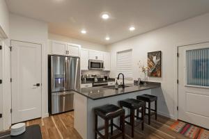 a kitchen with a sink and a counter with stools at The Railway Flats 102 in Missoula