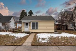 a small yellow house with snow on the yard at Slant Streets Bungalow in Missoula