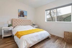 a bedroom with a bed with a yellow blanket on it at The Railway Lofts 201 in Missoula