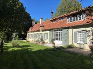an old house with a red roof and a yard at La Haute Trémière in Charenton sur Cher