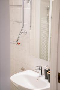 a white bathroom with a sink and a shower at Central Studio, Near City & Tram - Brämaregården in Gothenburg +37 photos