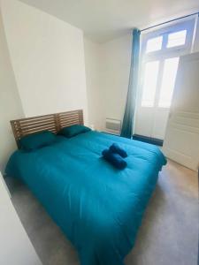 a blue bed in a room with a window at Charmant T2 centre ville N 4 in Marmande