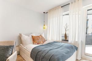 a bedroom with a bed and a couch and a window at Goldstadt Mosaik Apartment in Pforzheim