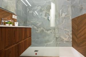 a bathroom with a shower with a stone wall at Relais Malta Luxotel in Salerno