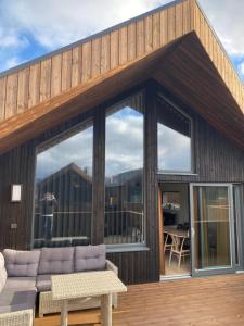 a house with large windows and a couch on a deck at Nordheim Aparment in Tromsø