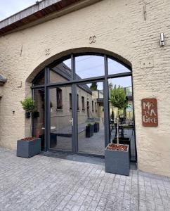 ein Eingang zu einem Gebäude mit einer großen Glastür in der Unterkunft MMGhome - Gîte à la ferme in Frasnes-lez-Anvaing