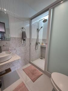 a bathroom with a shower and a toilet and a sink at ICB Suites in Tagbilaran City