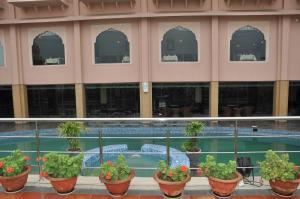 un edificio con piscina con plantas en macetas en The Royal Retreat, en Ranchi