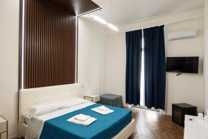 a bedroom with a bed with a blue blanket at Relais Malta Luxotel in Salerno