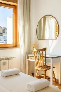 a bedroom with a desk and a chair and a mirror at Suite Enes Terrazza con vista e relax in centro città in Trieste