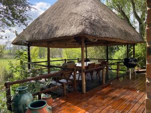 einen Pavillon mit einem Tisch und Stühlen auf einer Terrasse in der Unterkunft Rosetta River Retreat in Mooirivier
