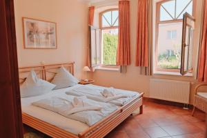 a bedroom with a bed with white sheets and windows at Residenz-Seestern-Whg-31 in Kühlungsborn