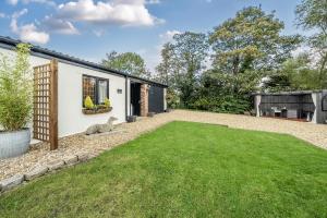 a garden with a lawn in front of a house at The Stables in Hambleton