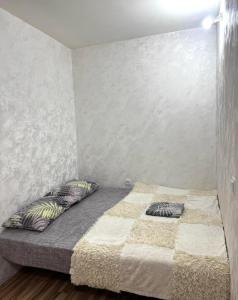 ein Bett in einem Zimmer mit zwei Kissen darauf in der Unterkunft Апартаменты в центре города in Chişinău