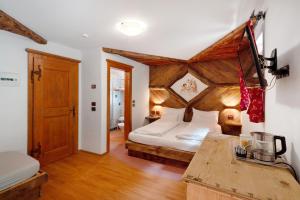 a bedroom with a bed with a wooden ceiling at Agritur Agua Biencia in Pera