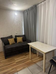 ein Wohnzimmer mit Sofa und Tisch in der Unterkunft Апартаменты в центре города in Chişinău