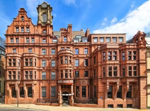 an old red brick building with a clock tower at The Met Hotel Leeds - Newly Refurbished in Leeds