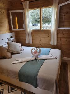 two swans are sitting on a bed in a room at Calao in Tijoco de Abajo