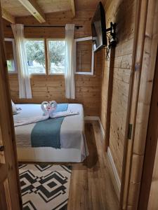 a bedroom with a bed in a wooden cabin at Calao in Tijoco de Abajo +4 photos