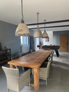 a dining room with a wooden table and chairs at la ferme au bois dormant in Wemaers-Cappel