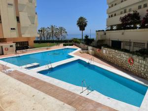 una grande piscina accanto a un edificio di The Suit III Marbella Center - EaW Homes a Marbella
