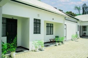 a white house with potted plants in the courtyard at Maasai Villa in Arusha