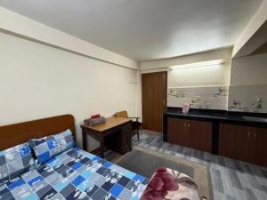 a bedroom with a bed and a sink and a desk at Homely in Kathmandu