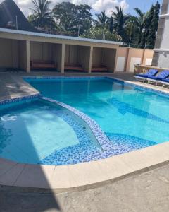 a large blue swimming pool in a building at Pamitos Sunny Paradise in Diani Beach in Diani Beach +6 photos