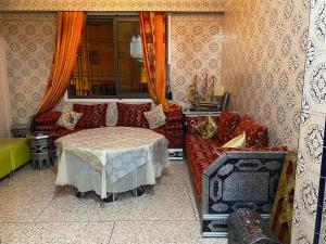 una sala de estar con un sofá y una mesa en Appartement oulfa, en Casablanca 1 foto más