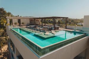 a swimming pool with lounge chairs on a building at Sayulita Serenity in Sayulita
