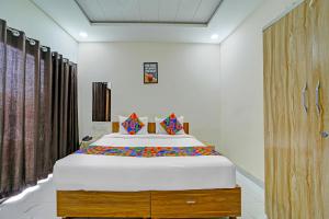 インドールにあるFabHotel Cressidaのベッドルーム1室(大型ベッド1台、カラフルな枕付)